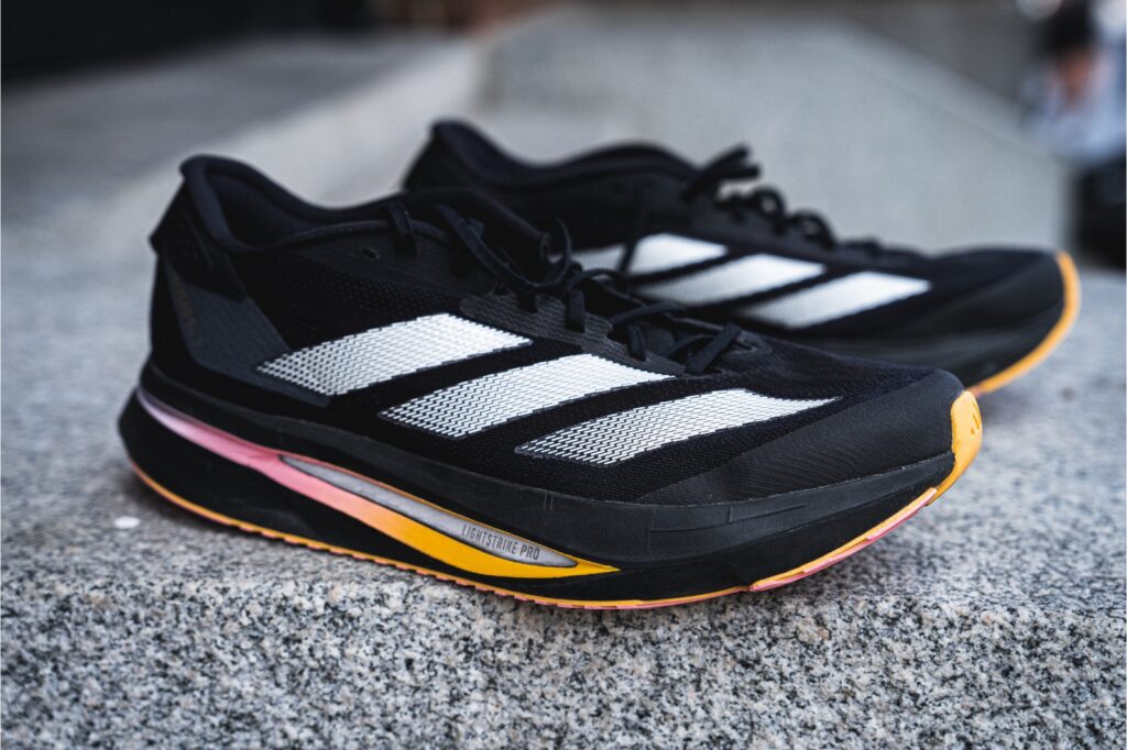 black pair of adidas running shoes with white stripes