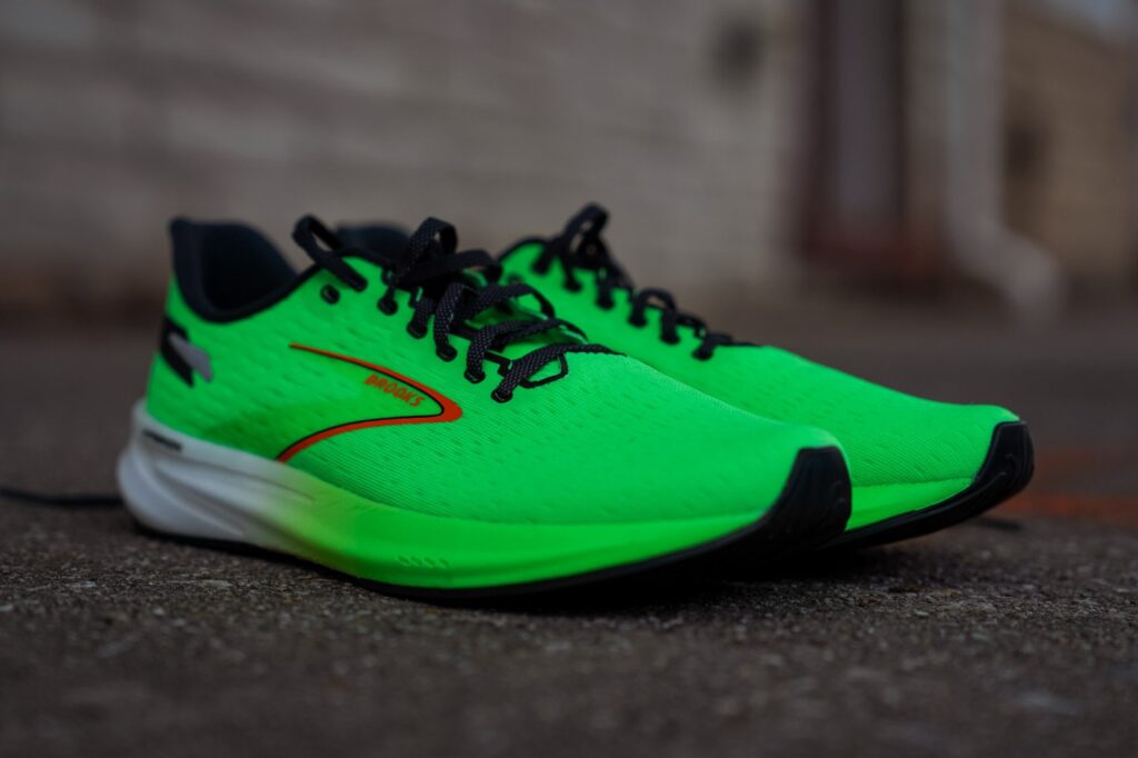 A Brooks Hyperion running shoe in black and green.
