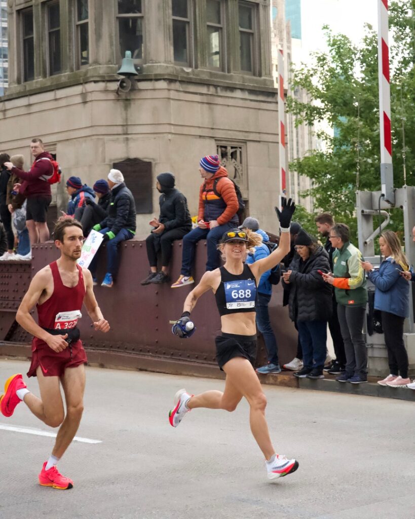 woman waving while running a marathon