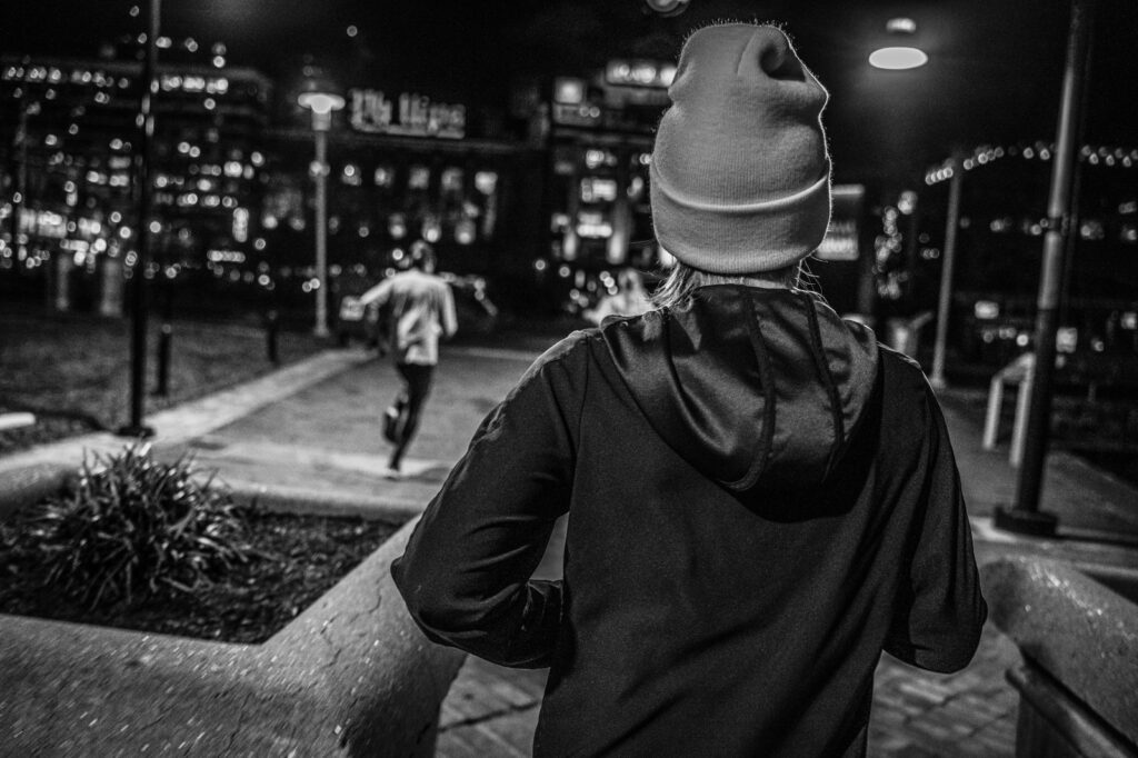 back of a woman running with winter cap