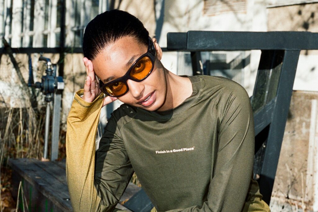 girl with sunglasses in forest green running shirt